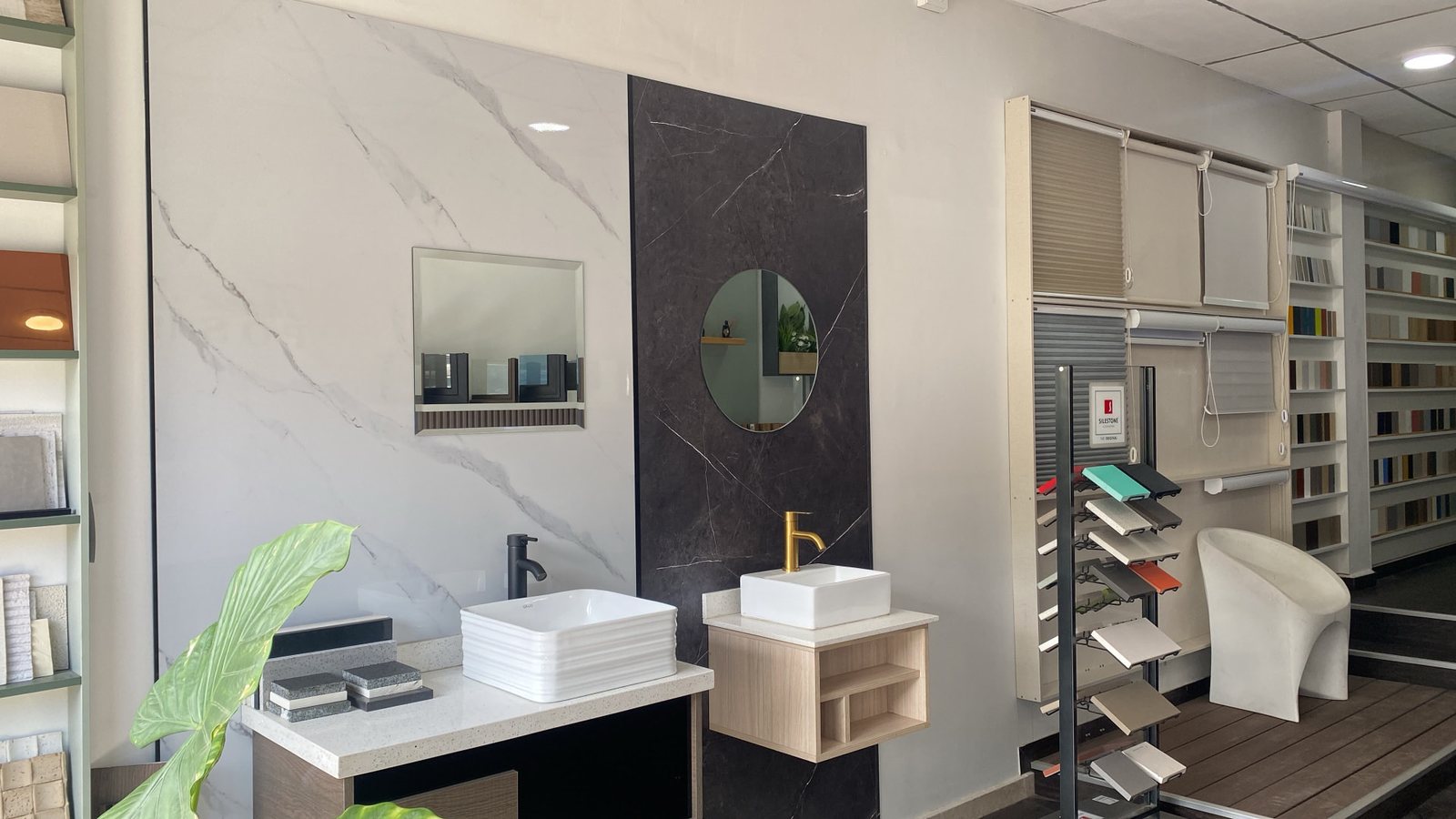 Vista general del showroom de Embelezzia: lavamanos sobre cubiertas, paneles tipo mármol y exhibidores