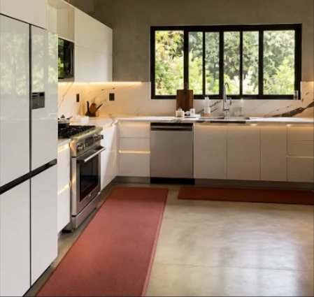 Cocina con gabinetes blancos, cubierta clara e iluminación lineal bajo los muebles